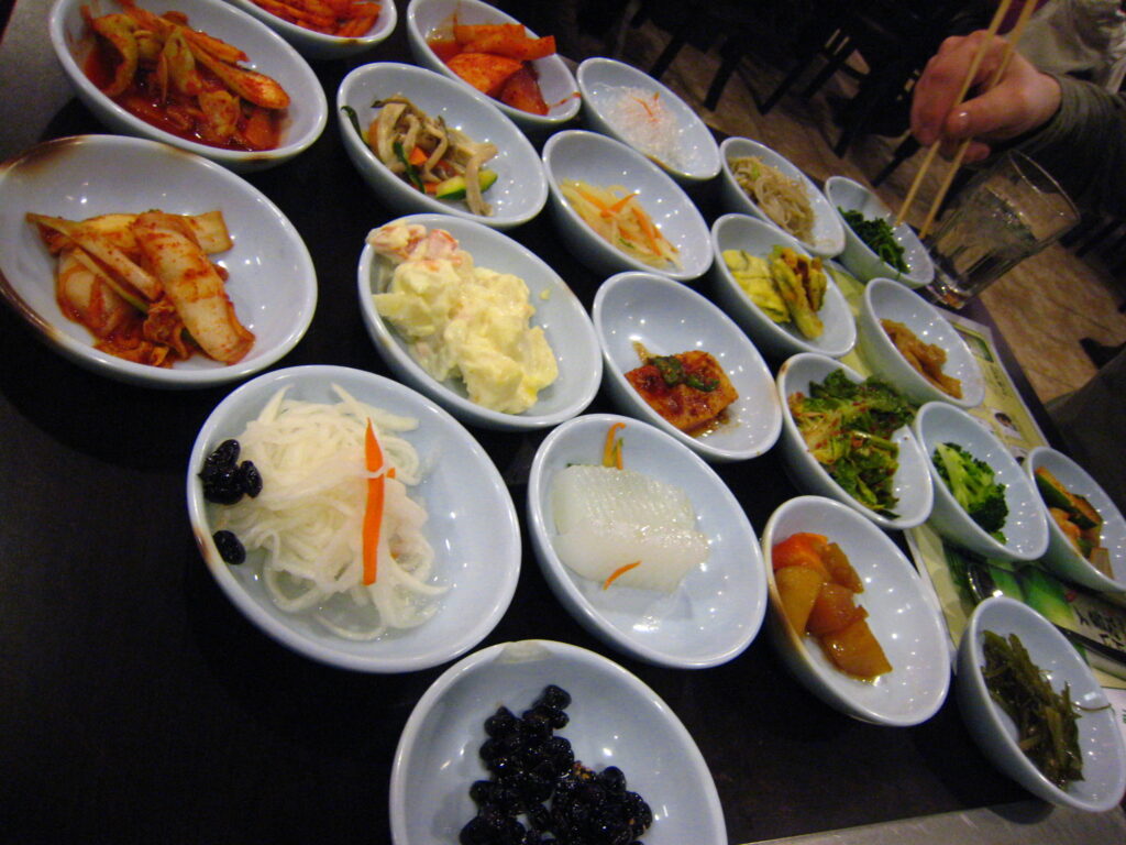 A wide spread of small Korean side dishes covering a table